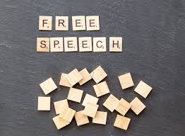 A table with scrabble tiles and the words free speech.